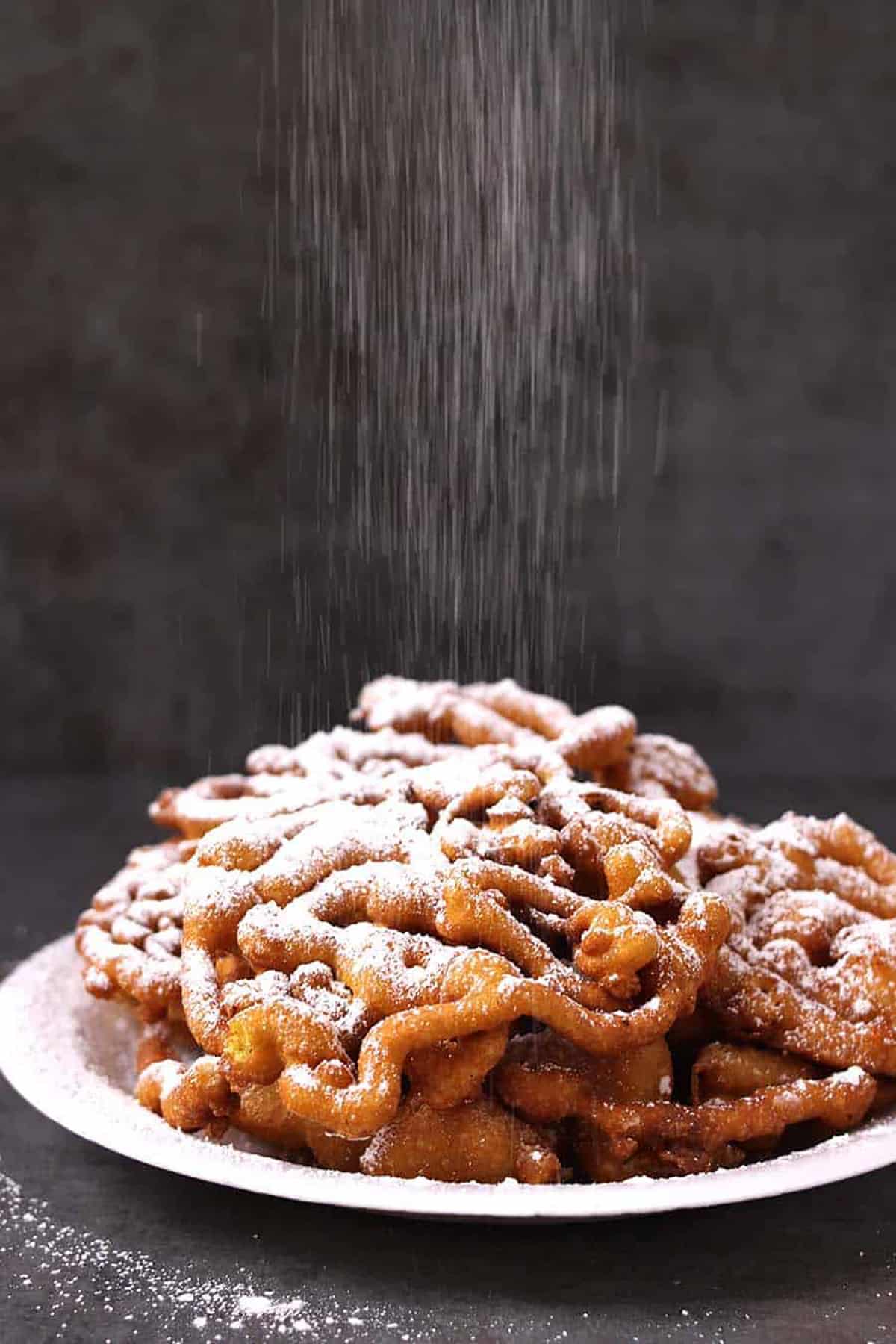 Best, easy funnel cake sprinkled with confectioners sugar #statefairfood #carnivalfood