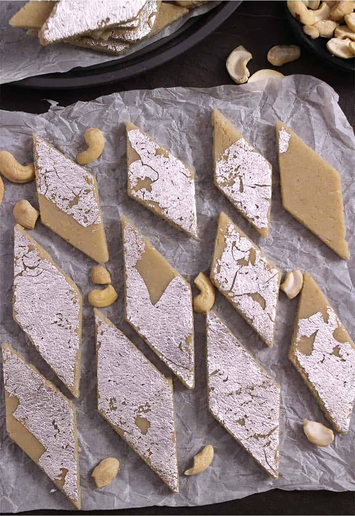Tip view of kaju katli or burfi with silver vark on parchment paper