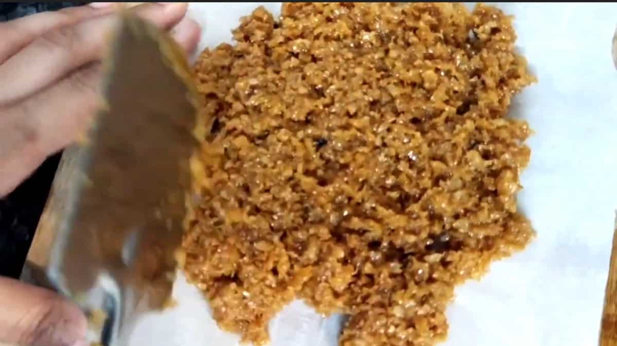 Spread the coconut jaggery burfi on a greased plate or parchment paper. 