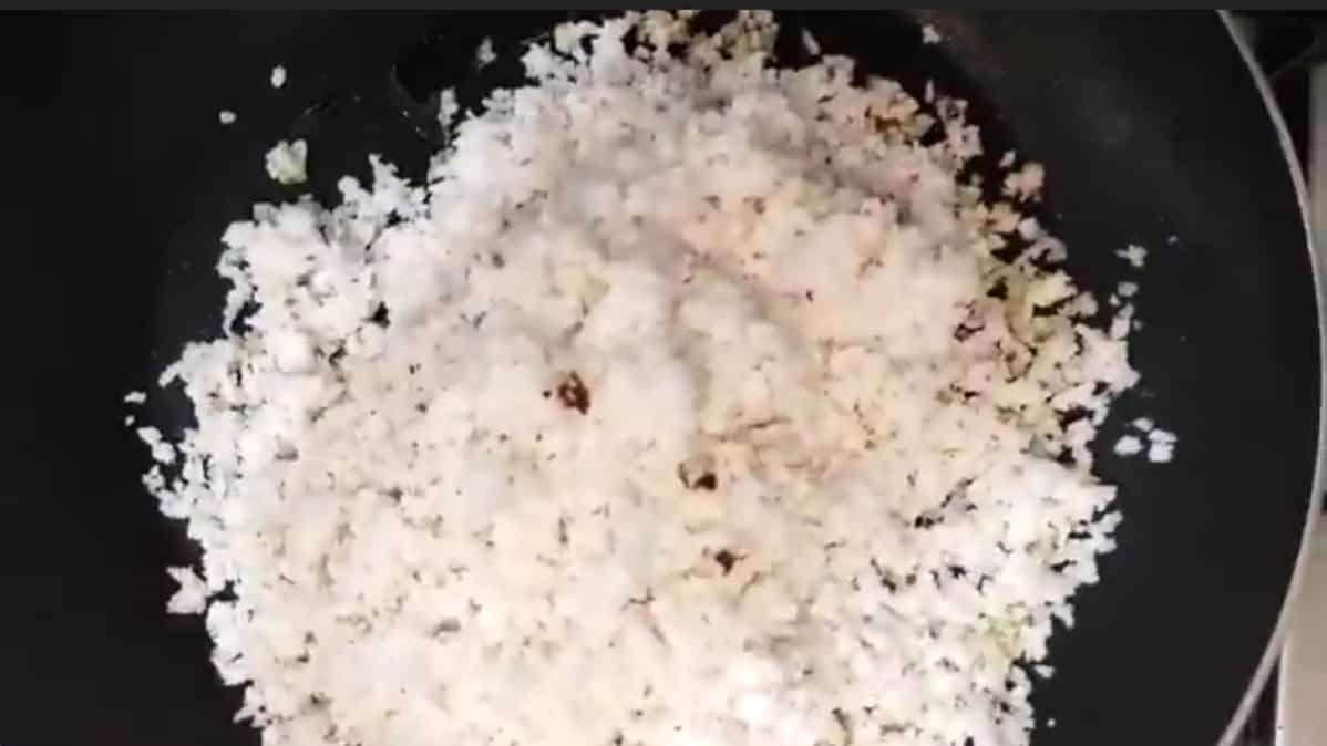 Add freshly grated coconut to the pan. 
