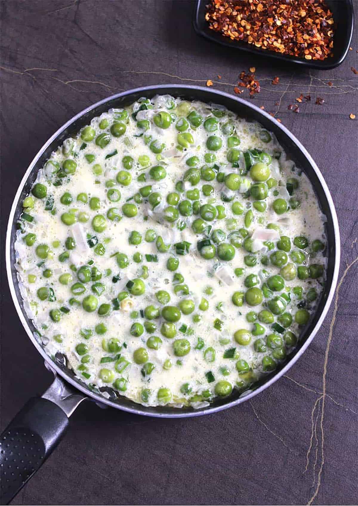 Top view of creamed peas in a nonstick pan.