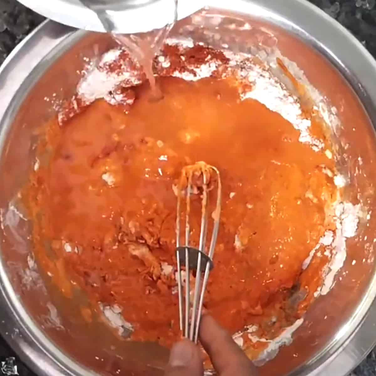 Adding water to form batter. 