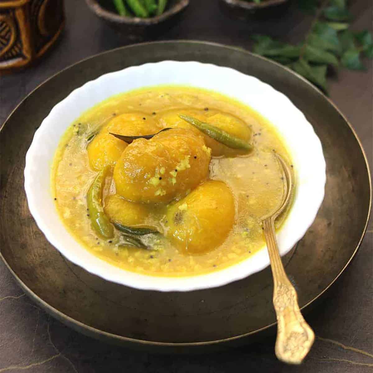 Vegan mango curry served in white bowl. 