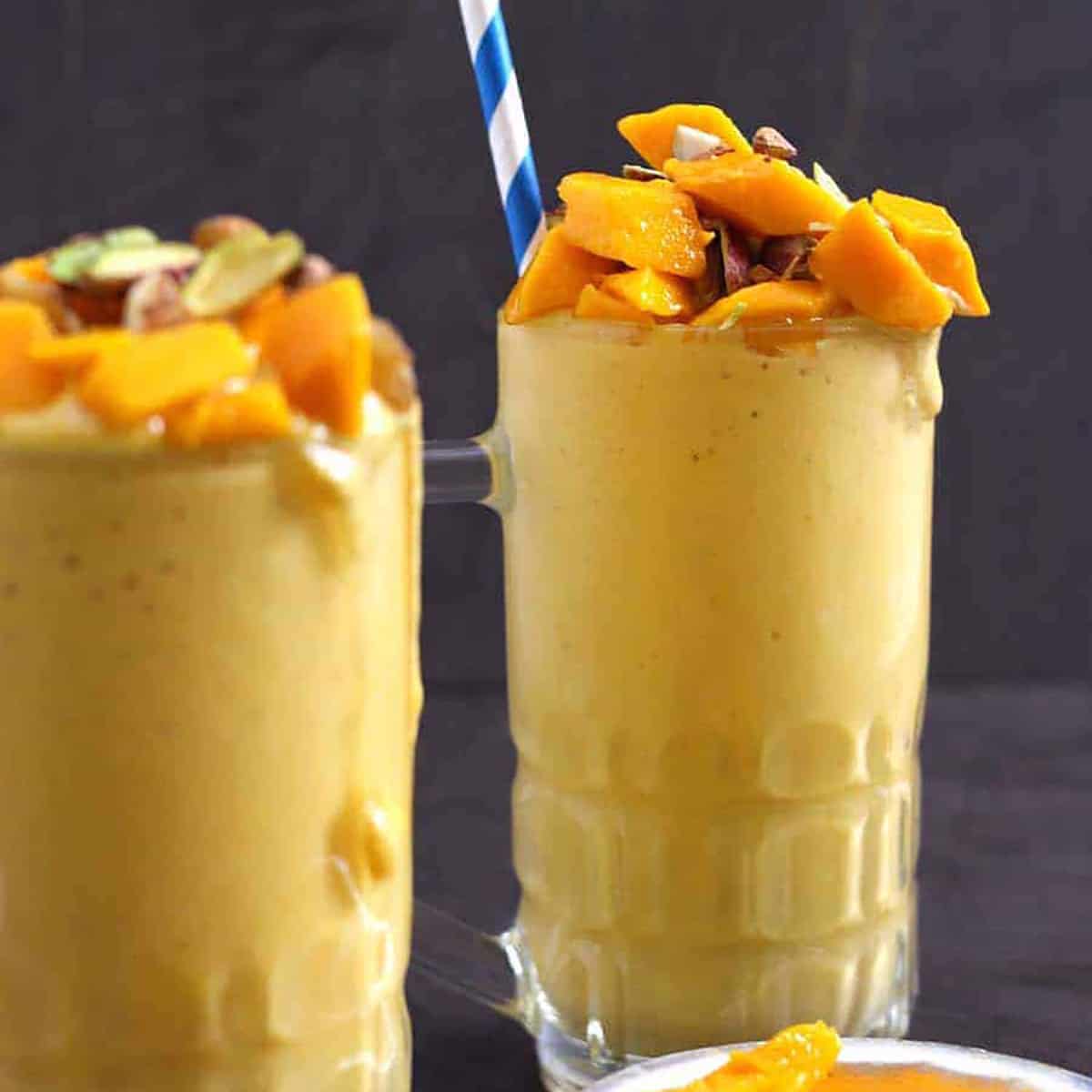 Thick and creamy mango mastani milkshake topped with mango chunks and pistachios.