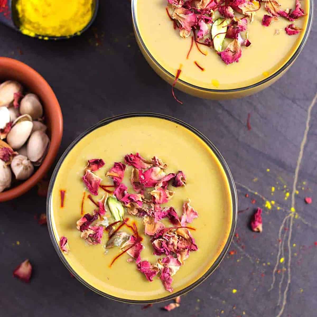 Mango thandai garnished with rose petals and pistachios. 