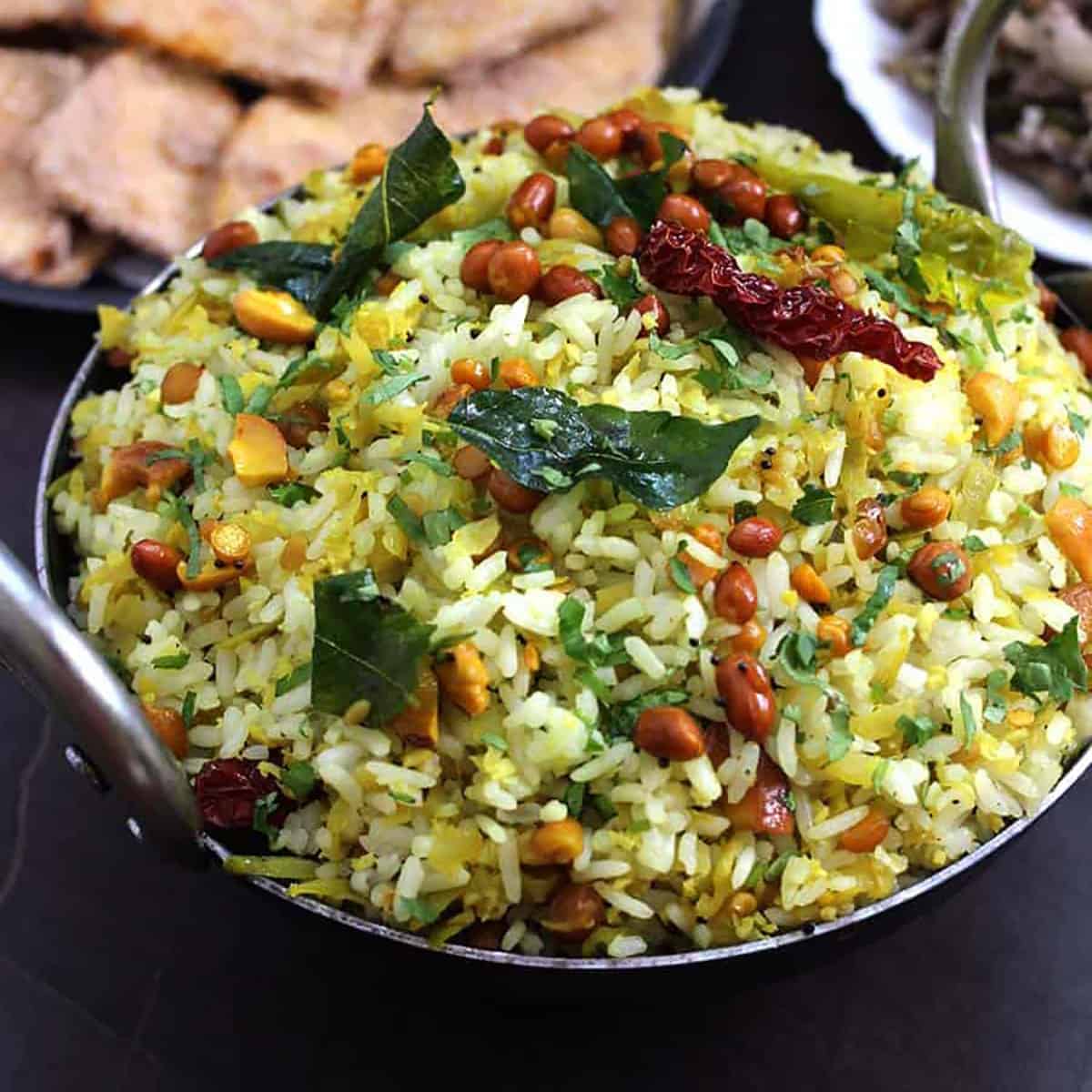 Raw mango rice (chitranna) garnished with a tempering of curry leaves, red chilies, and peanuts. 