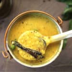 Pepper dal, holding laddle full of konkani style dalitoy.