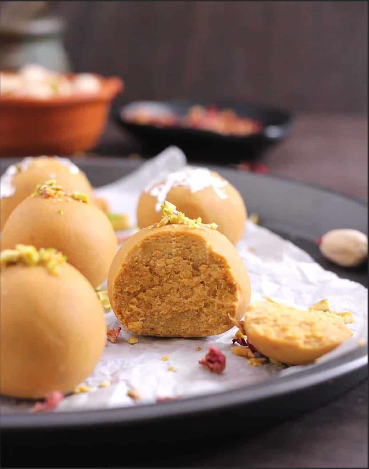 Besan Ladoo is broken into half to show the interior texture of the ladoo.