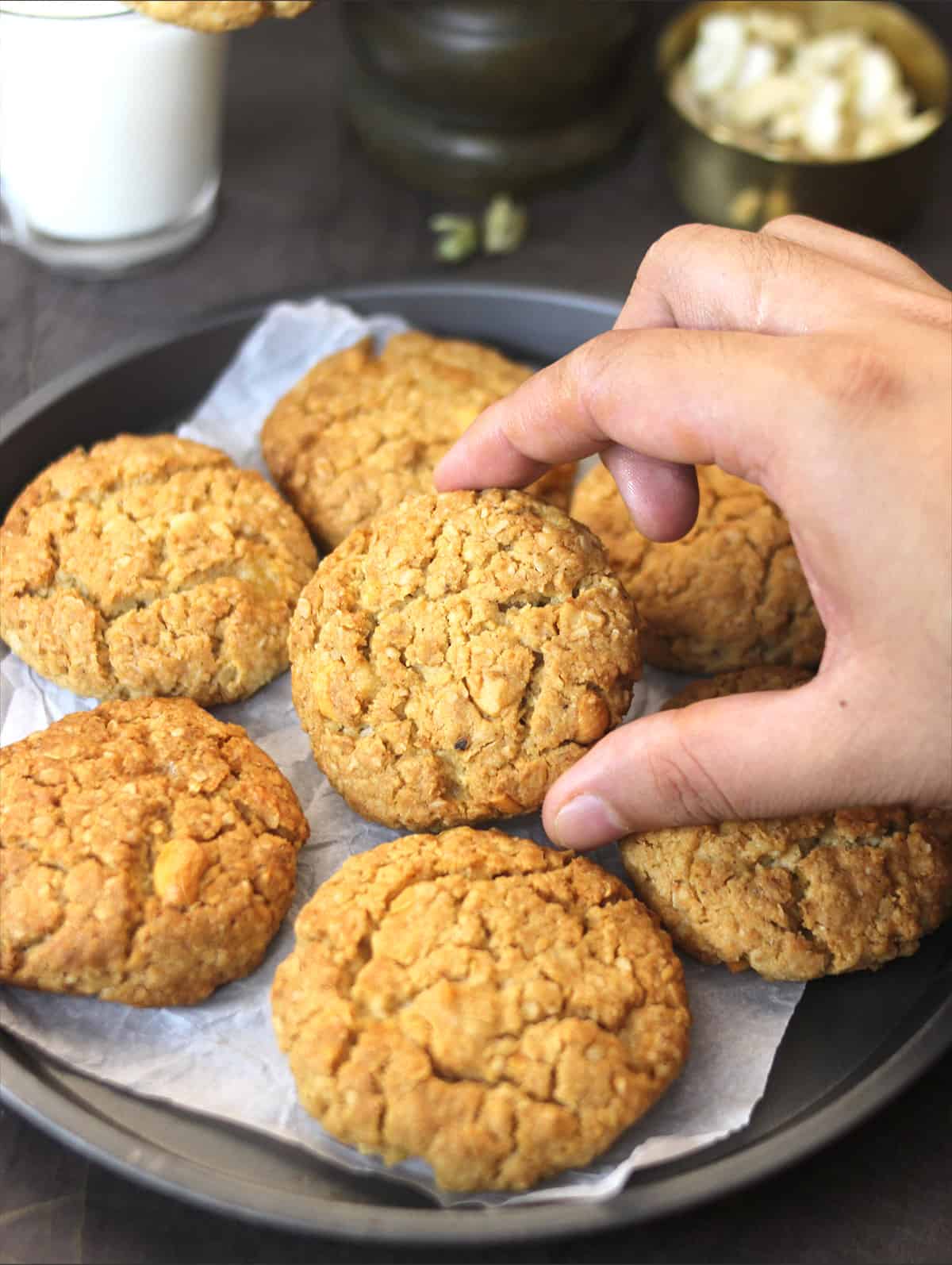 Whole Wheat Oatmeal Jaggery Cookies holding one cookie