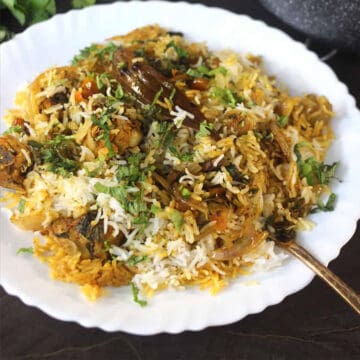 Homemade chicken biryani served in a white plate.