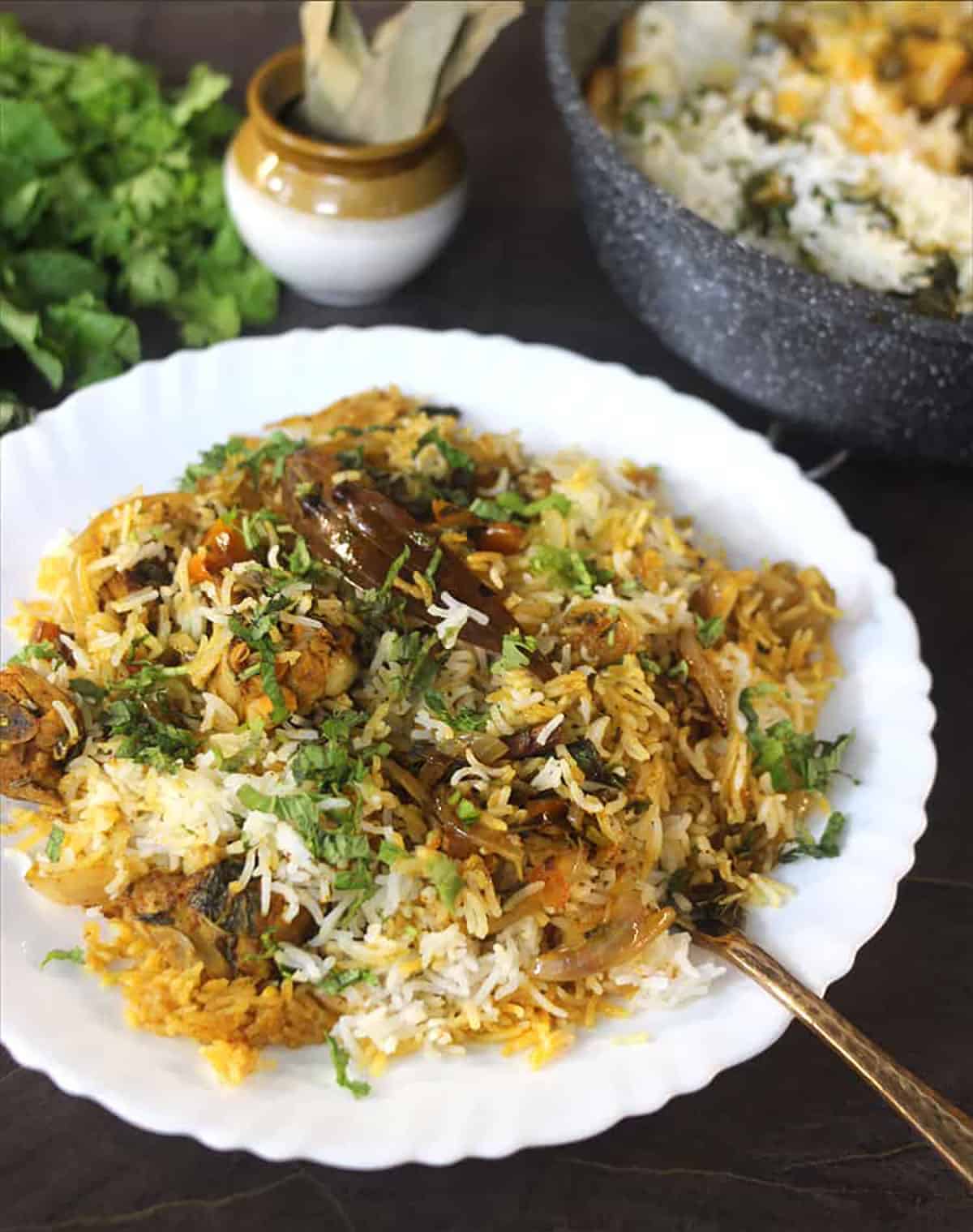 side view of a white plate containing chicken biryani. 