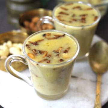 jackfruit payasam or chakka pradhaman served in two serving glass garnished with dry fruits and toasted coconut.