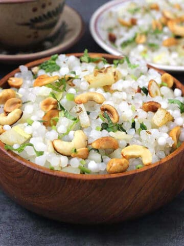 Sabudana Khichidi, garnished with toasted peanuts and cashews served in a wooden bowl.