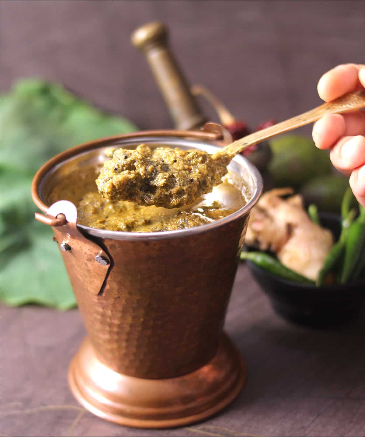 Healthy patra leaves curry, holding temple style alvati in golden spoon