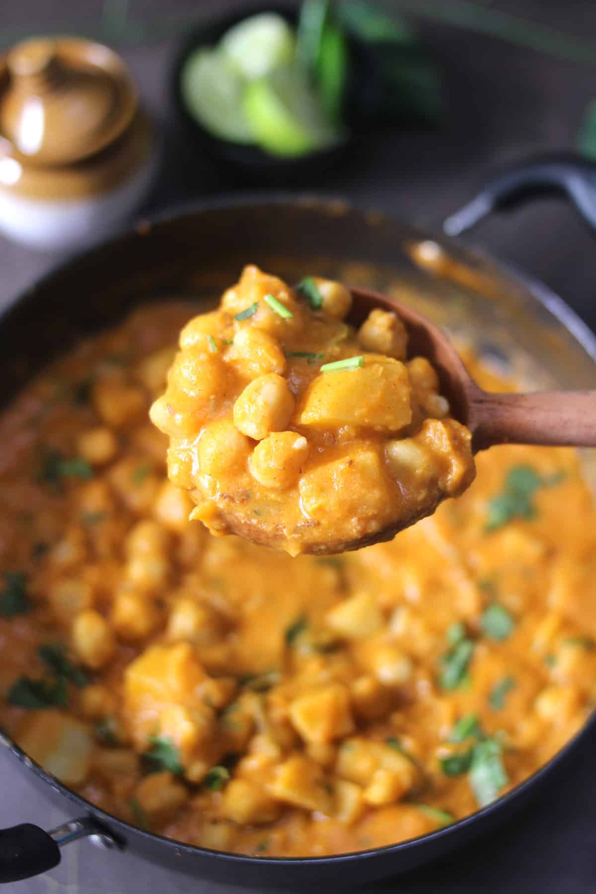 Holding laddle of vegan  chickpeas curry or chana masala