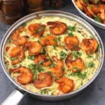 Top view of shrimp scampi with spaghetti pasta garnished with finely chopped cilantro.