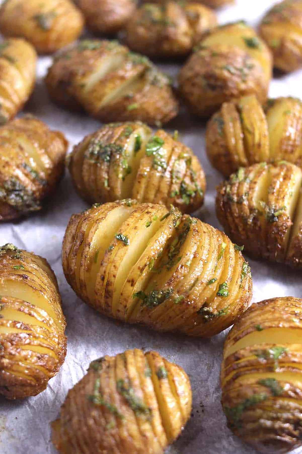 Side view of Hasselback Potatoes in a baking pan.