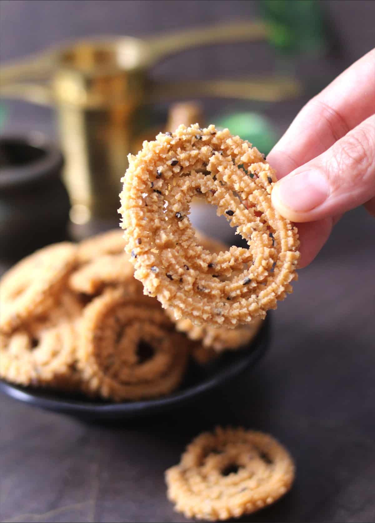 Holding Crispy Chakli or murukku, best Indian snack recipe for Diwali,