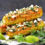 delicious mexican style corn on the cob served with a drizzle of spicy mayo, along with a sprinkle of cojita cheese and finely chopped cilantro.