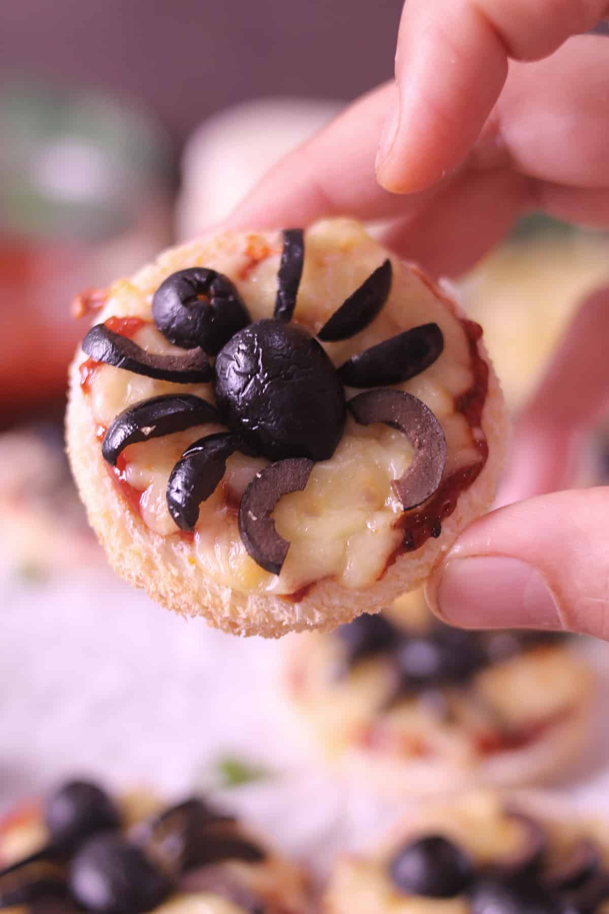 Holding mini coin bread pizza, best party appetizer or evening snack for kids 
