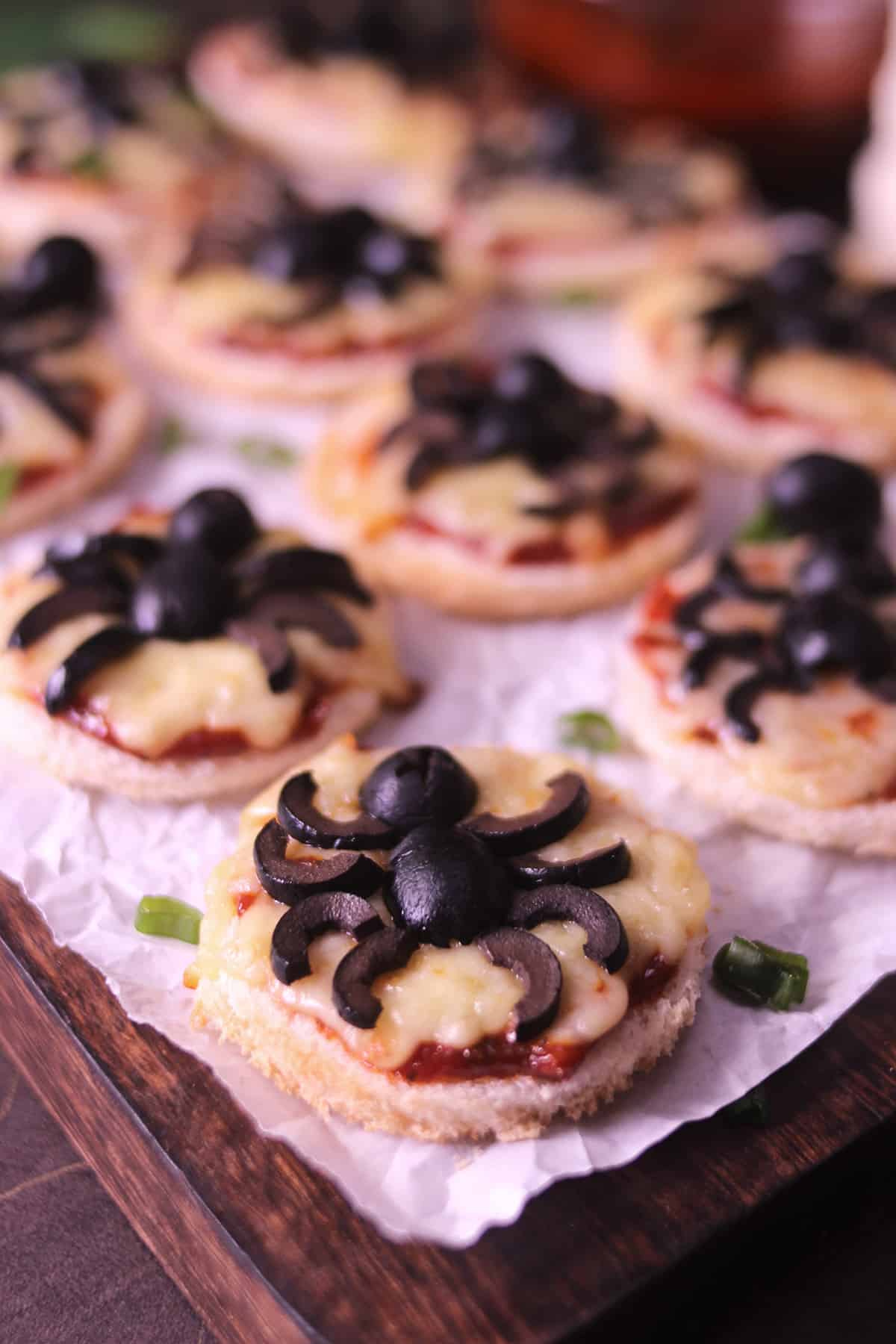 Halloween themed pizza with bread, mozzarella cheese, pizza sauce and black olives