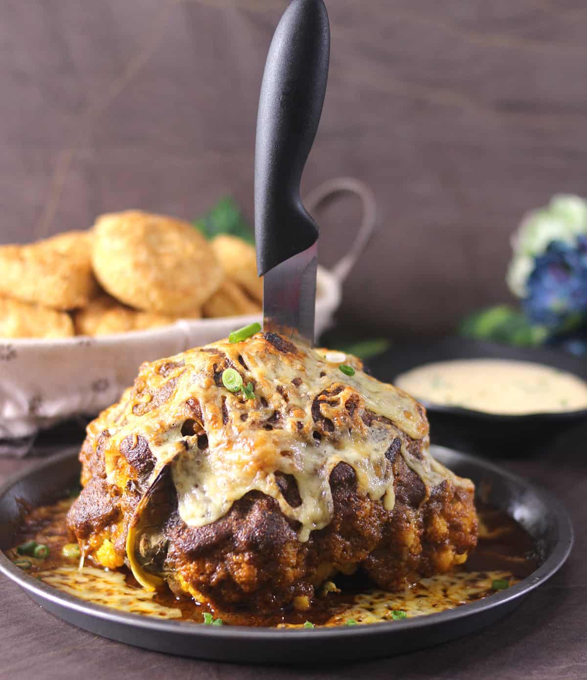 Best whole roasted cauliflower head topped with cheese and garlic cream sauce.