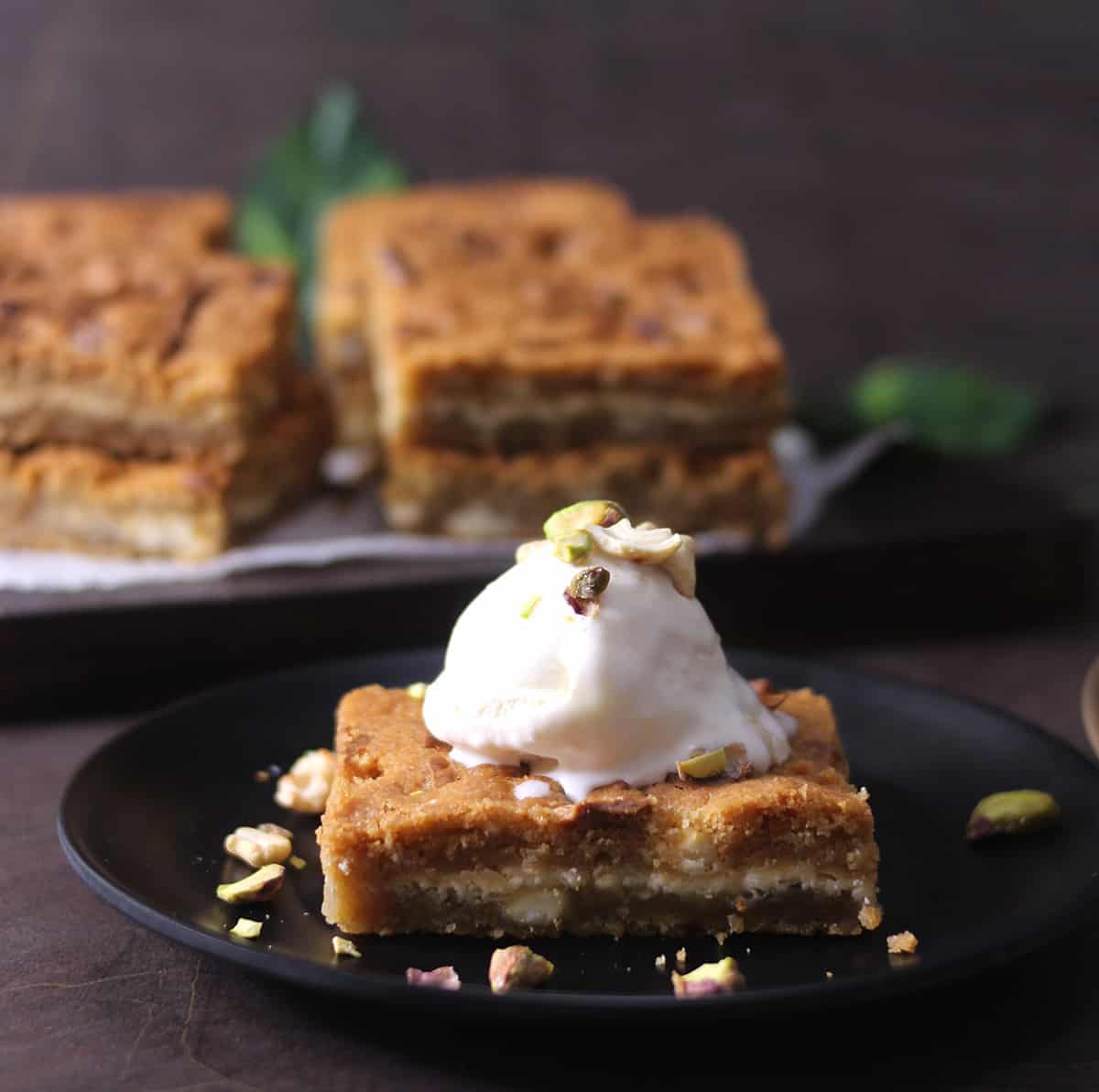 blondies served with vanilla ice cream garnished with nuts 