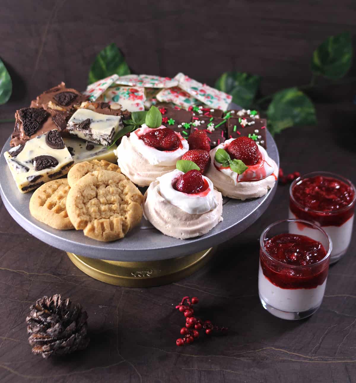 christmas dessert board with pavlova, no bake fudge, candy barks, peanut butter cookies, brownies