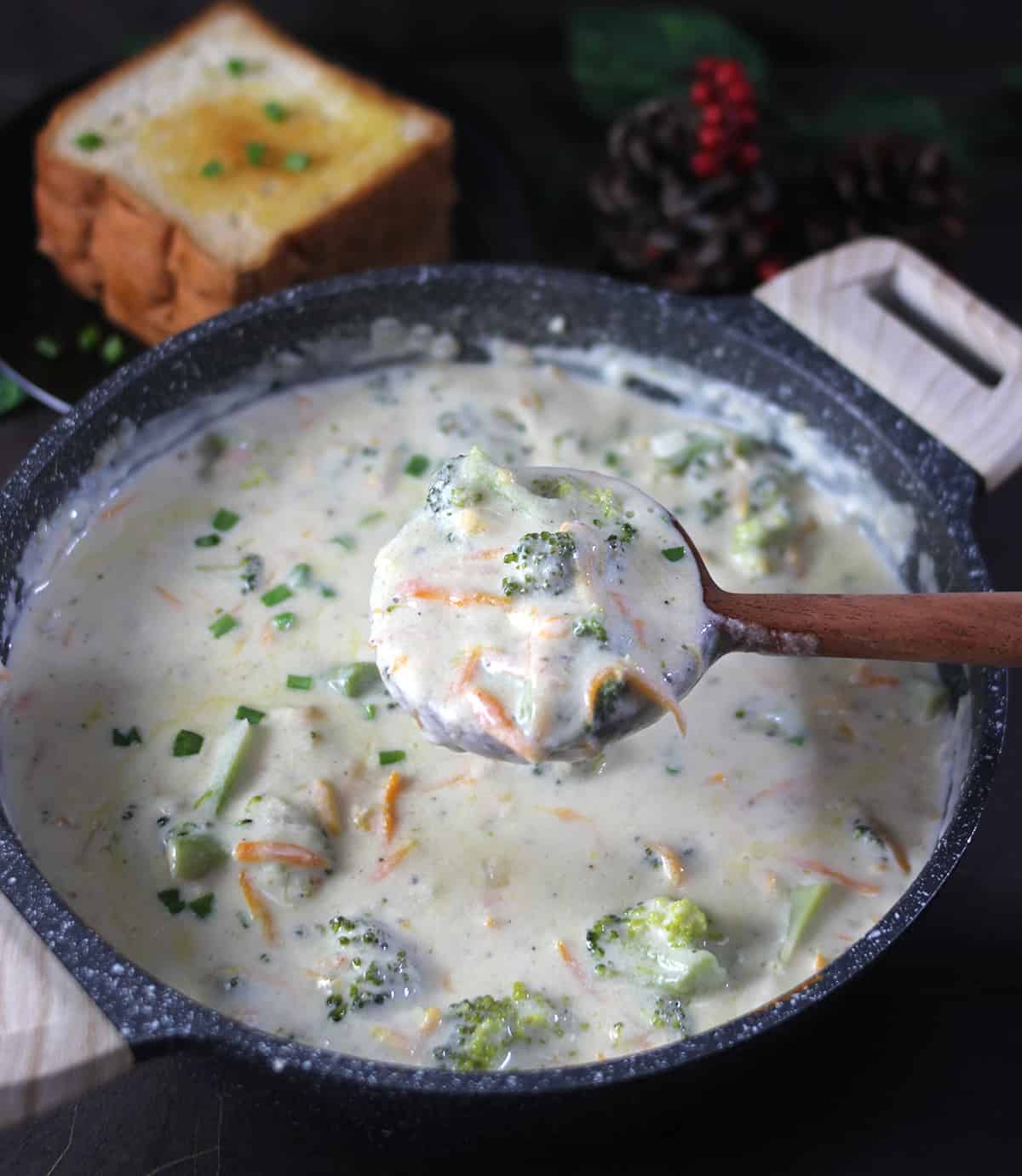 Holding laddle full of cheddar broccoli soup recipe made with cream, cheese and milk 