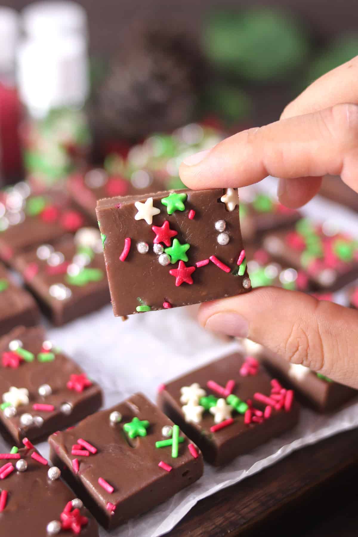 2 ingredient Christmas fudge or chocolate fudge decorated with Christmas-themed sprinkles. 