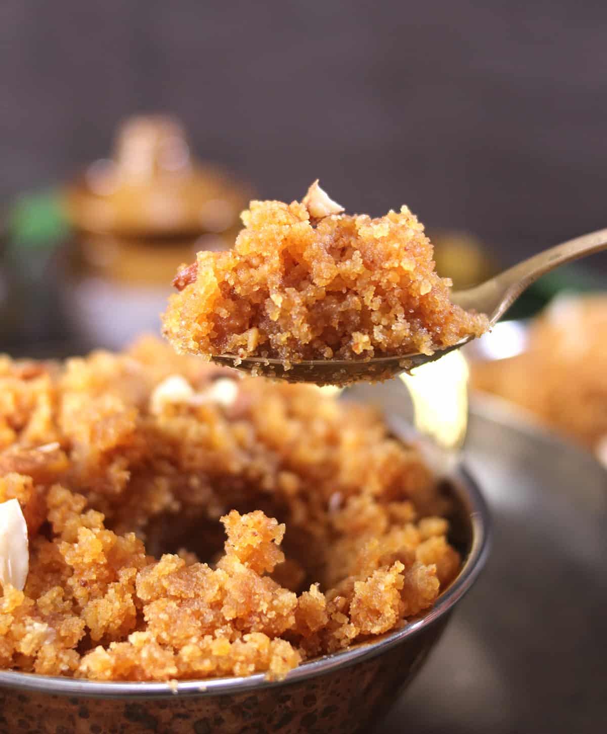 Holding spoon of fresh homemade rich and classic moong dal halwa recipe 