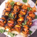 tandoori paneer tikka skewers served in a plate.