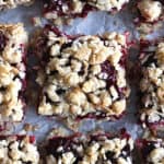 blackberry oatmeal bars on white parchment paper.