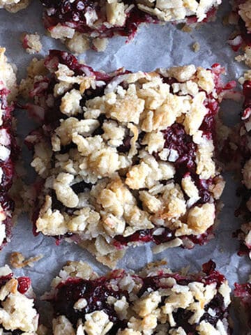 blackberry oatmeal bars on white parchment paper.