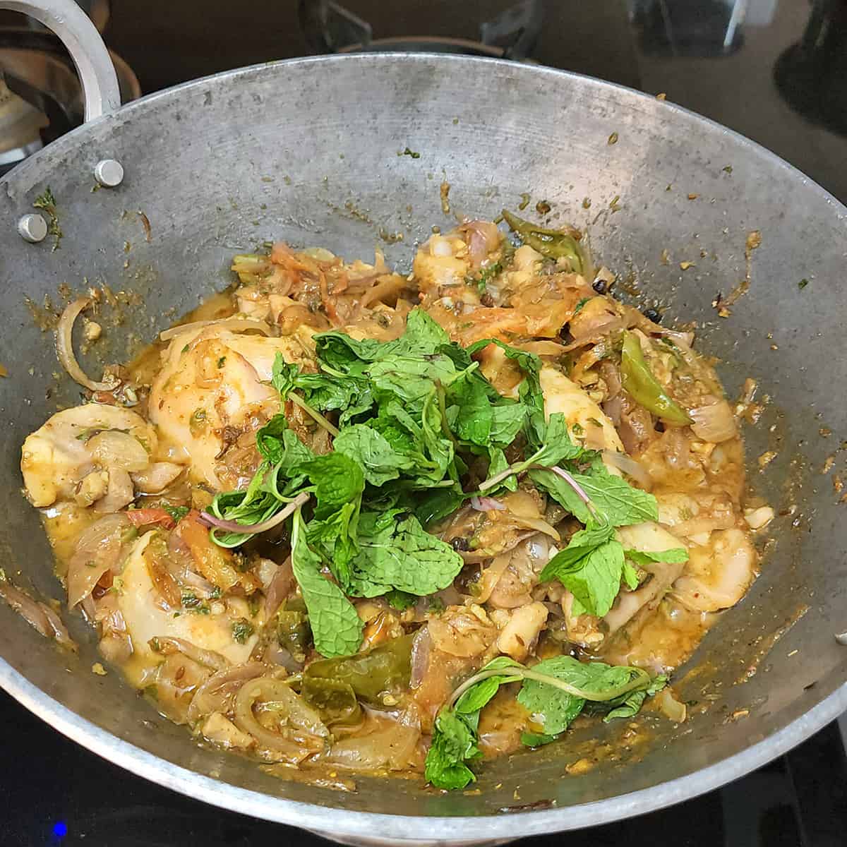 Mint leaves added to partially cooked chicken while making the most flavorful murgh pulao.