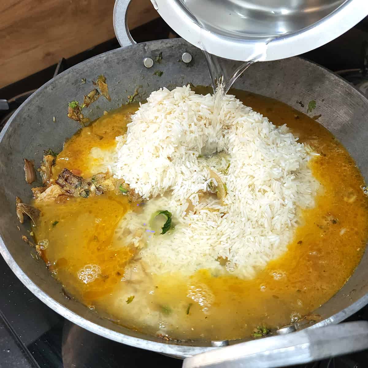 Add water to the pan to cook the rice.