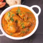 A bowl of best and easy, chicken handi curry garnished with coriander leaves.