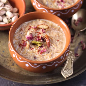 Sheer Khurma dessert served warm in bowl garnished with dry fruits, nuts, saffron, rose petals.