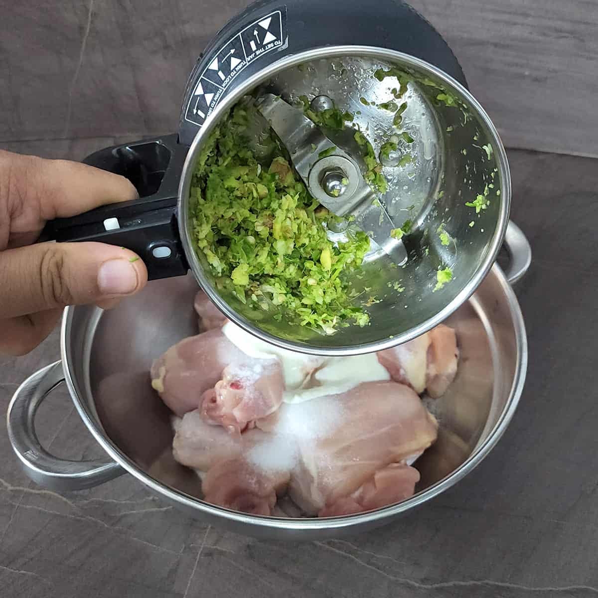 Add the coarse paste of fresh ginger, garlic and green chilies from blender to marinate chicken. 