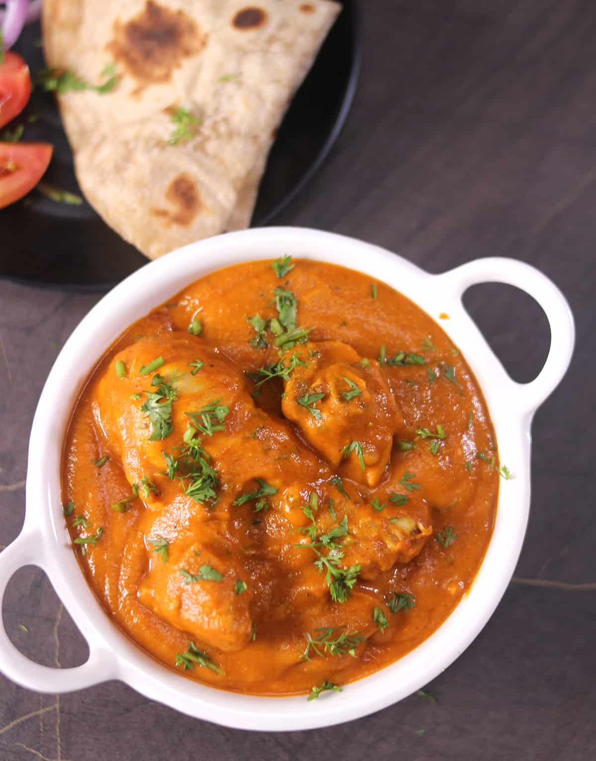 Bowl of spicy chicken handi served with chapati (roti).