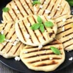 Feta cheese stuffed mini flatbreads with flavors of fresh basil served in a black plate.