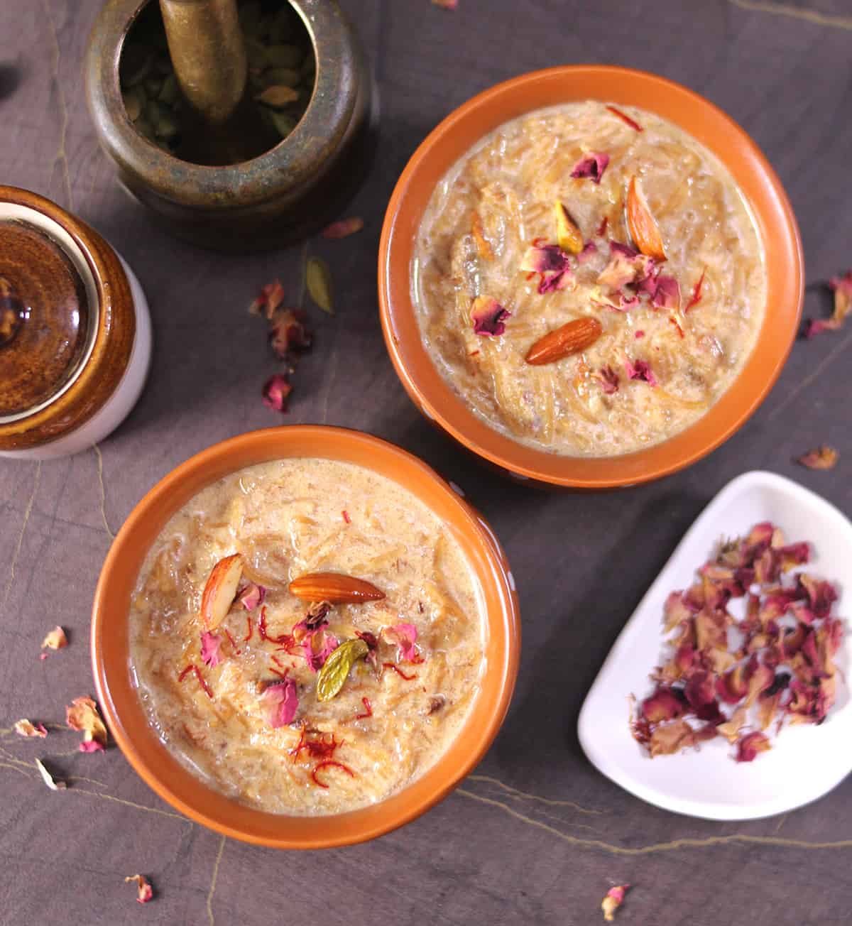 Top view of eid seviyan kheer dessert served in bowl garnished with dried fruits, nuts, rose, saffron. 