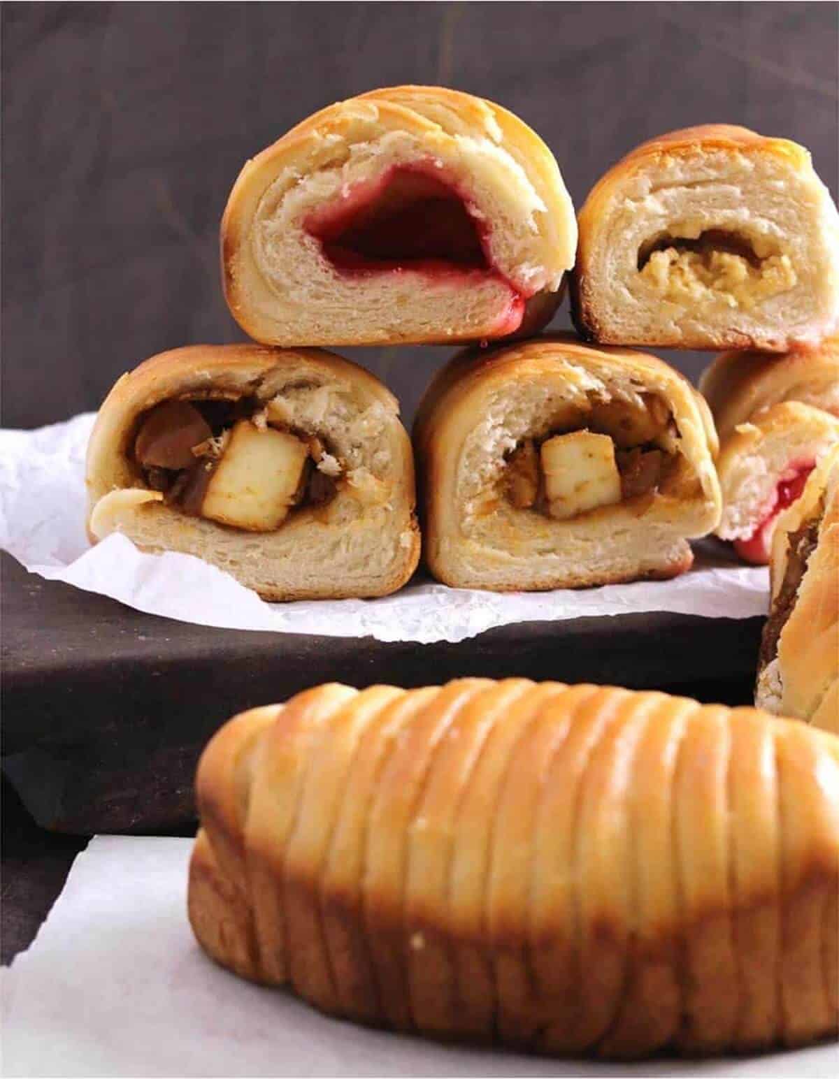 Sweet and savory wool roll bread sliced into half and stacked on top of each other.