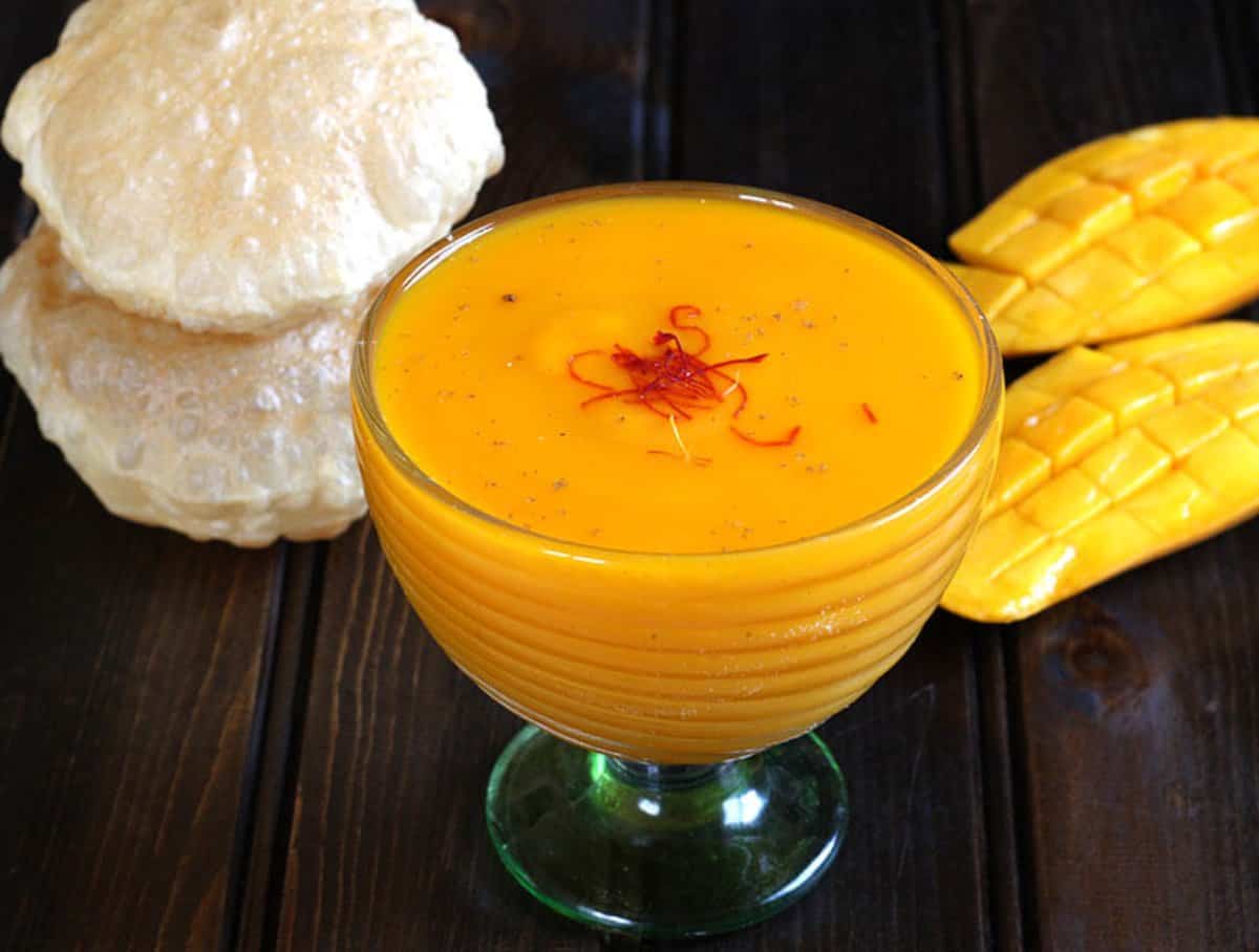 Easy to make Aamras or Flavored Sweet Mango Pulp served in a glass bowl and garnished with saffron.