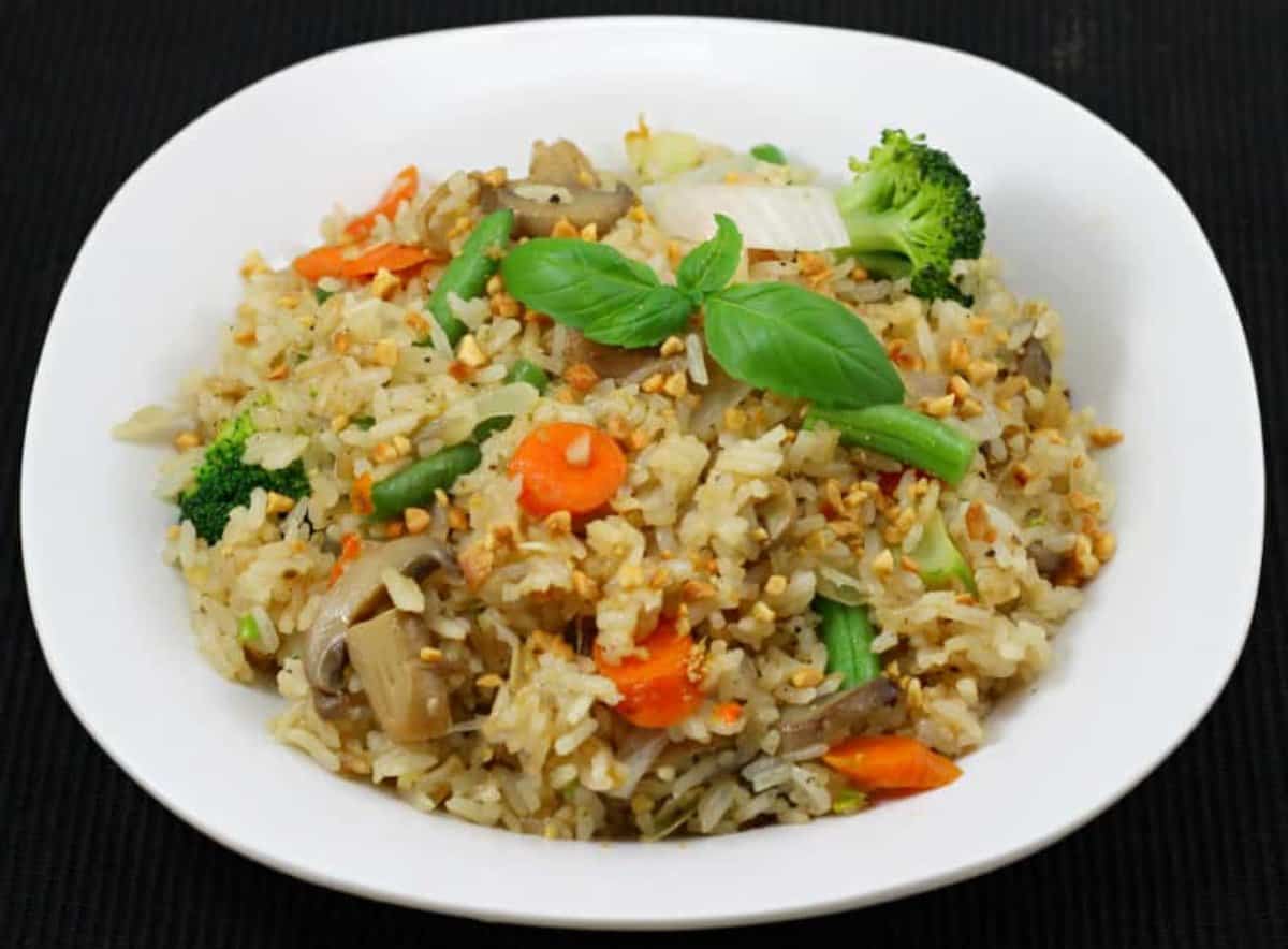 Simple restaurant-style Basil Fried Rice (Khao Pad or Khao Phat) served in a white plate.