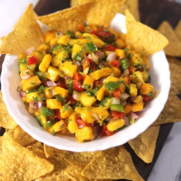 best mango salsa in a white bowl served with tortilla chips.
