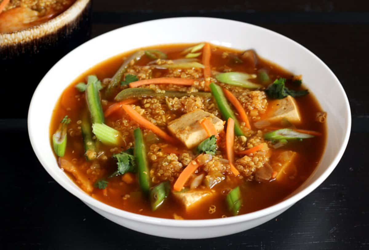 Easy Homemade Quinoa Soup with Tofu and vegetables served in a white ceramic bowl.