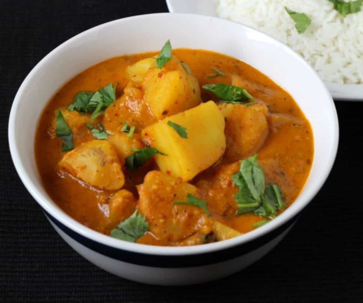 Quick and Easy Aloo Vindaloo served in a white ceramic bowl along with steamed rice.