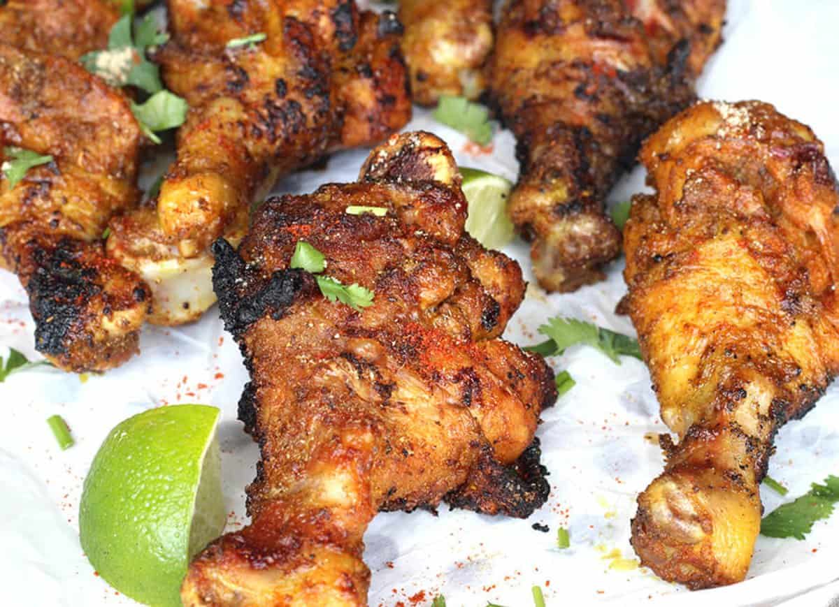 Quick and easy Tandoori Grilled Chicken garnished with cilantro and lemon wedges.