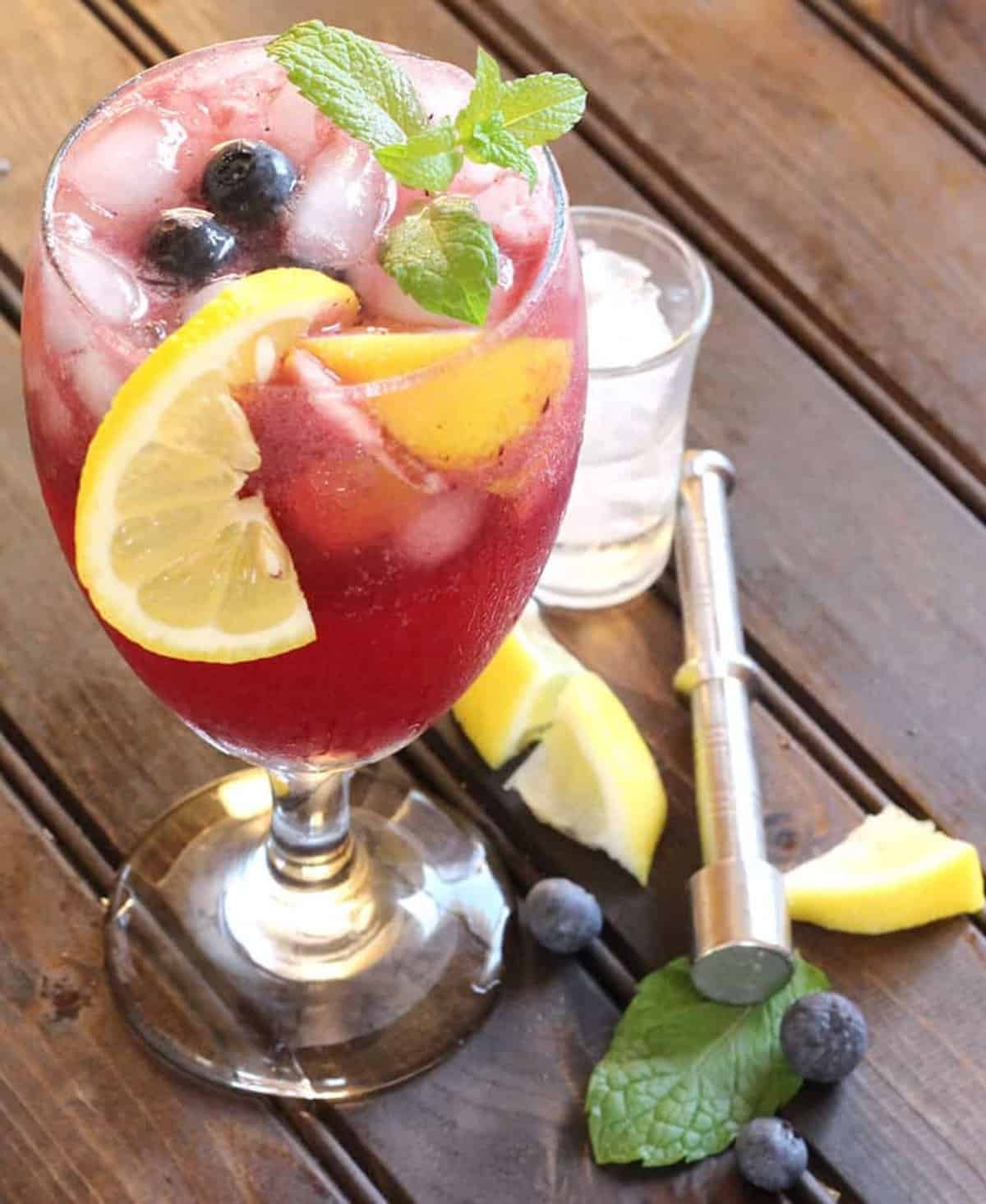 Quick and easy blueberry mojito mocktail served in a tall glass.